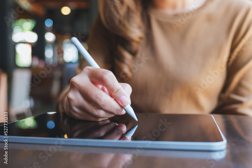 Closeup of a woman using smart pen technology for working and writing on digital tablet screen