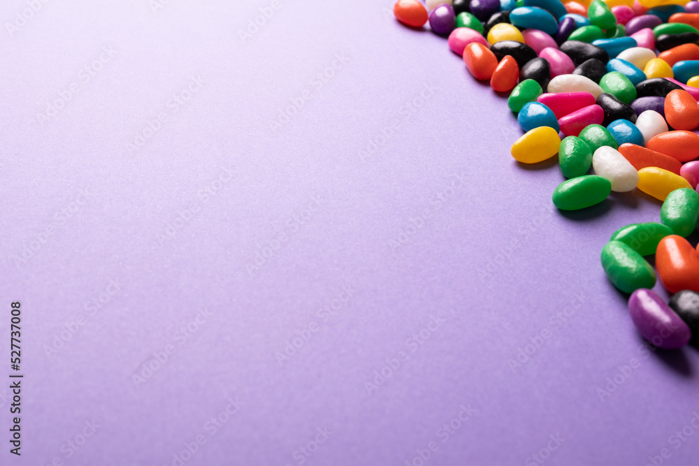 Close-up of copy space by multi colored sweet candies on purple background Close-up of copy space by multi colored sweet candies on purple background
