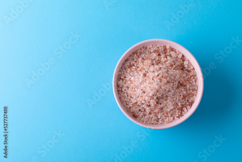 Overhead view of himalayan salt in bowl on blue background with copy space