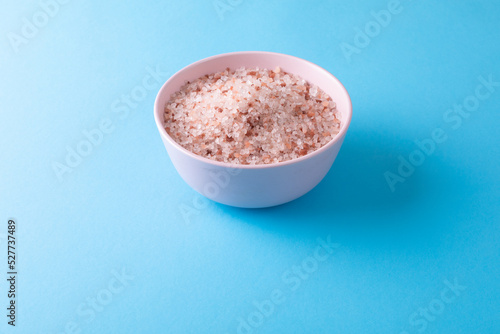 High angle view of himalayan salt in bowl on blue background with copy space