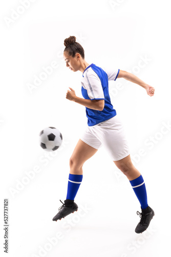 Side view of biracial young female player in mid-air kicking ball while playing soccer © wavebreak3