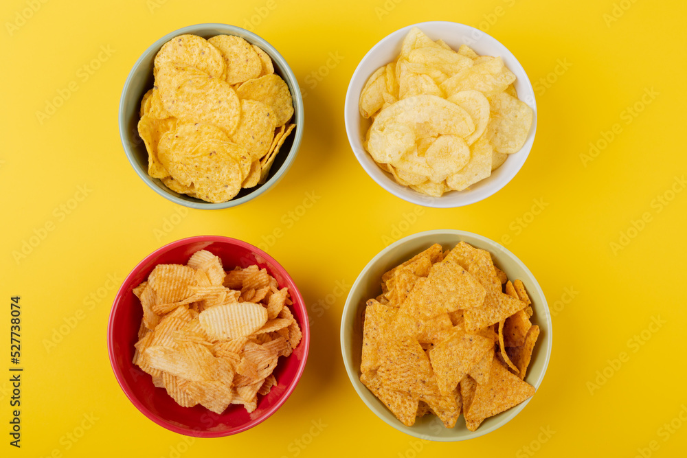 Directly above shot of various snacks in bowls on yellow background Directly above shot of various snacks in bowls on yellow background
