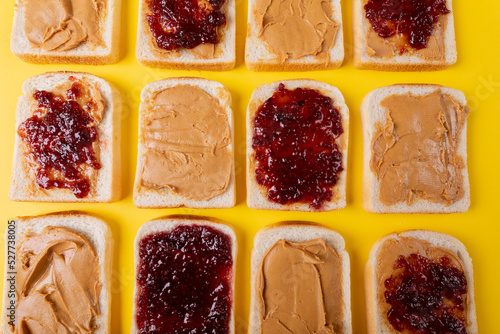 Directly above shot of bread slices with preserves and peanut butter arranged alternatively