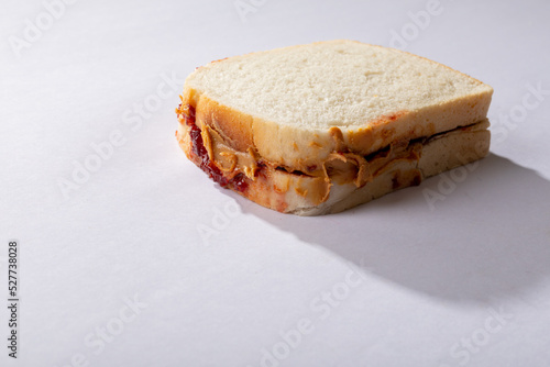 Close-up of peanut butter and jelly sandwich on white background with blank space
