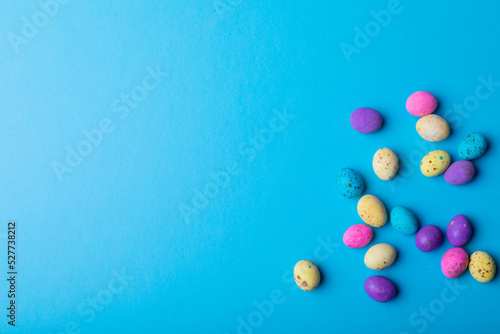 Overhead view colorful eater candies on blue background with copy space