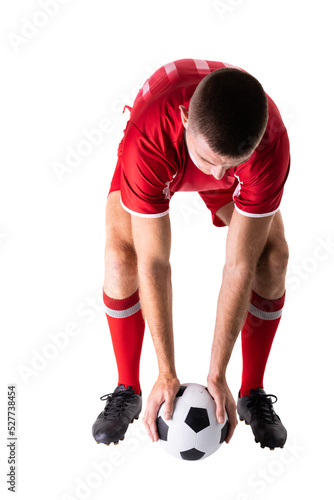 Young male caucasian player holding soccer ball positioning against white background