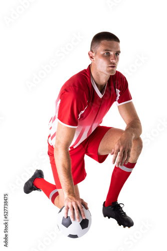Full length of caucasian young male athlete kneeling by soccer ball against white background