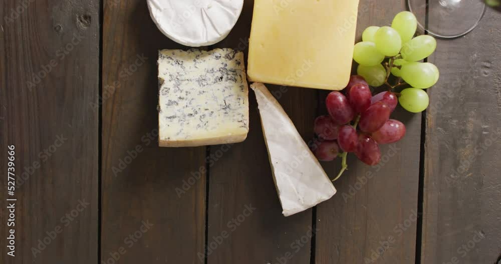 Video of diverse cheeses, grapes and wine on wooden surface Video of diverse cheeses, grapes and wine on wooden surface
