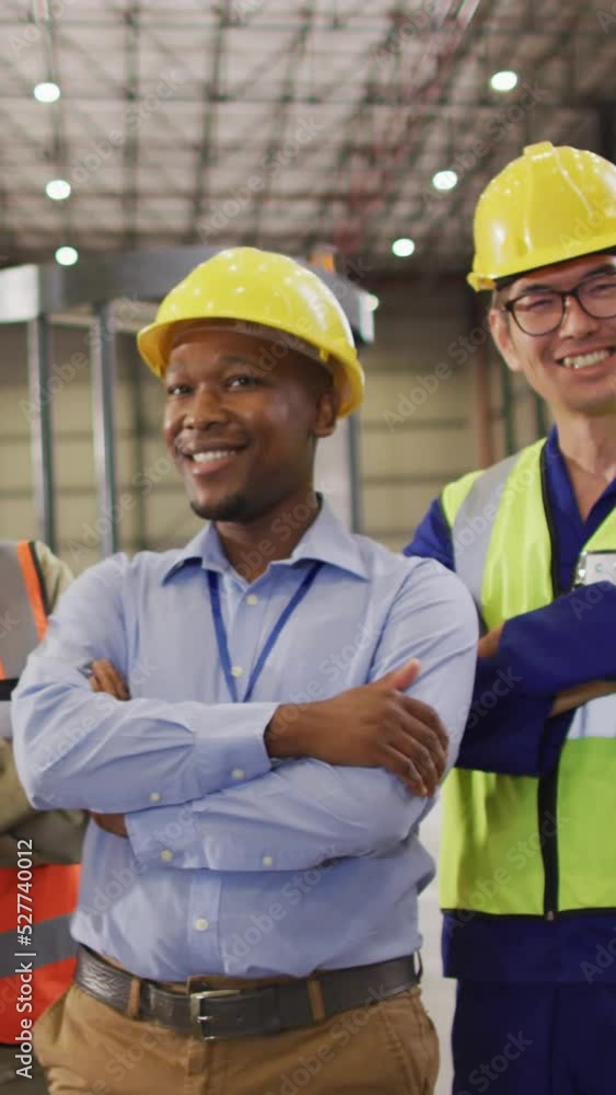 Portrait of diverse workers wearing safety suits and smiling in warehouse Portrait of diverse workers wearing safety suits and smiling in warehouse