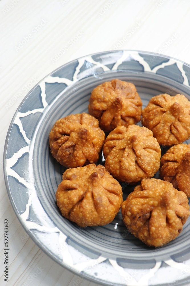 Fried Modak. It's a traditional sweet dish of coconut, jaggery, and dry fruits stuffed inside the wheat dough. Offered to Lord Ganesha during the Ganpati Chaturthi festival in India. with copy space. 
