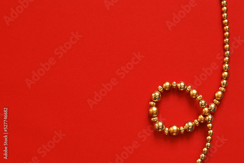 A top view of an emty surface with golden garland isolated on red background, Christmas concept