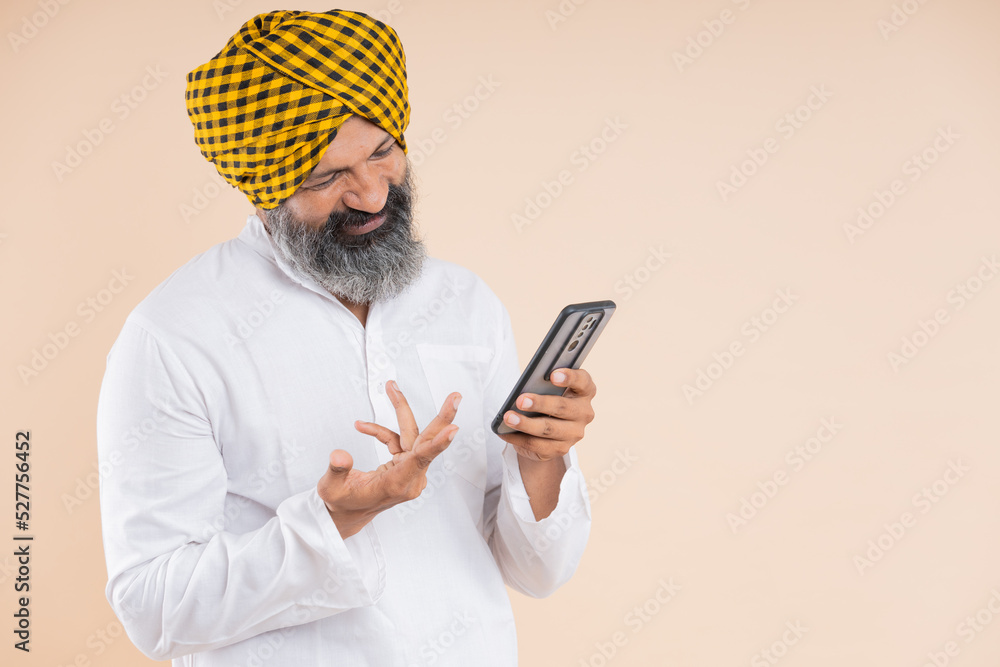 portrait of happy indian Sikh farmer using mobile portrait of happy indian Sikh farmer using mobile