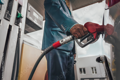 Canvas Print Young man refuelling his modern car at petrol station
