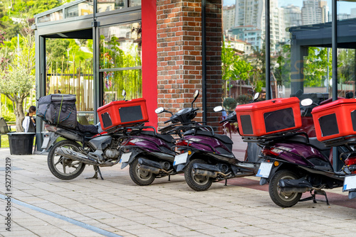 Food delivery motorbike with isothermal box parked on street