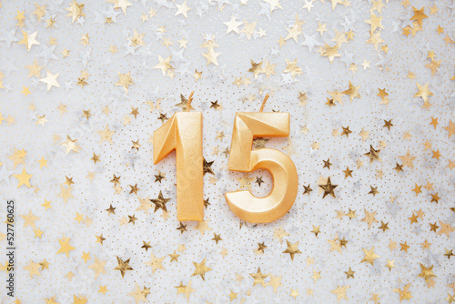 Number 15 fifteen golden celebration birthday candle on Festive Background. fifteen years birthday. concept of celebrating birthday, anniversary, important date, holiday photo