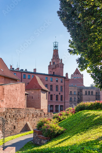 Widok na stare mury Poznania i zabytkową straż pożarną. 
