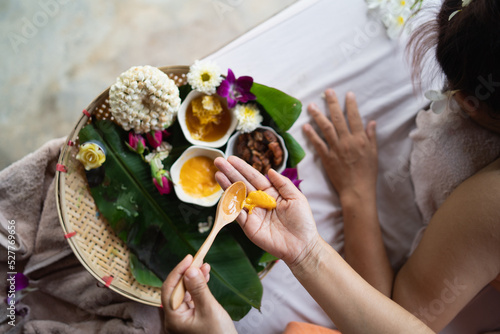 Hand of masseuse use honey for massage and spa relaxing treatment of office syndrome traditional thai massage style. Female masseuse doing massage scrup with salt treat back pain, arm pain and stress photo