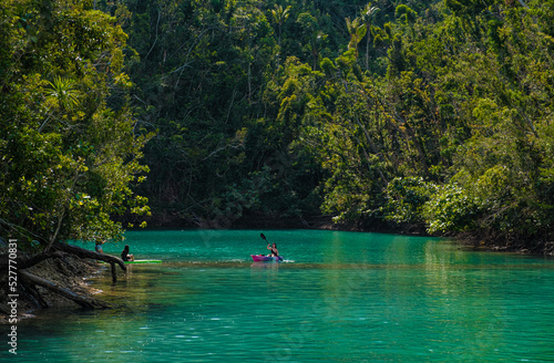 Woman kayaking in lagoon surrounded with beautiful nature