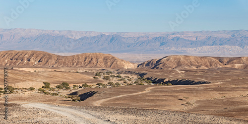 panorama of the Great Rift Valley from a hill above the Wadi Nahal Qatsra dry stream bed with the Jordan mountains in the background