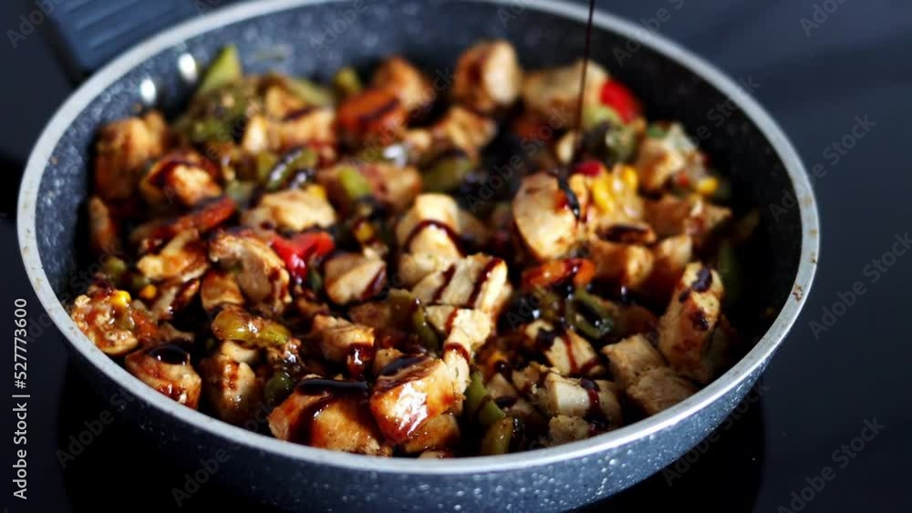 The chef pours sauce on vegetables with meat that is stewed in a pan. Cooking in a restaurant's kitchen. Slow-motion The chef pours sauce on vegetables with meat that is stewed in a pan. Cooking in a restaurant's kitchen. Slow-motion
