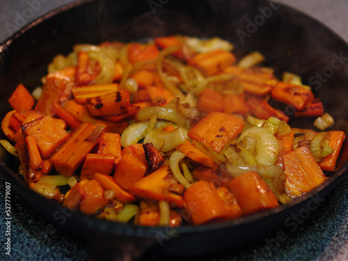 Carrots and onions roasting in a cast iron pan