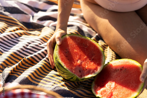 Cheerful young woman enjoy at tropical sand beach. Portrait of happy girl with fruit photo