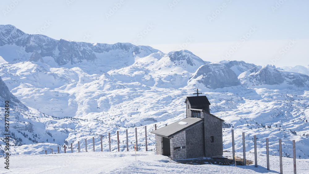 Small chapel on a snowy landscape surrounded by mountains, Austria, Europe