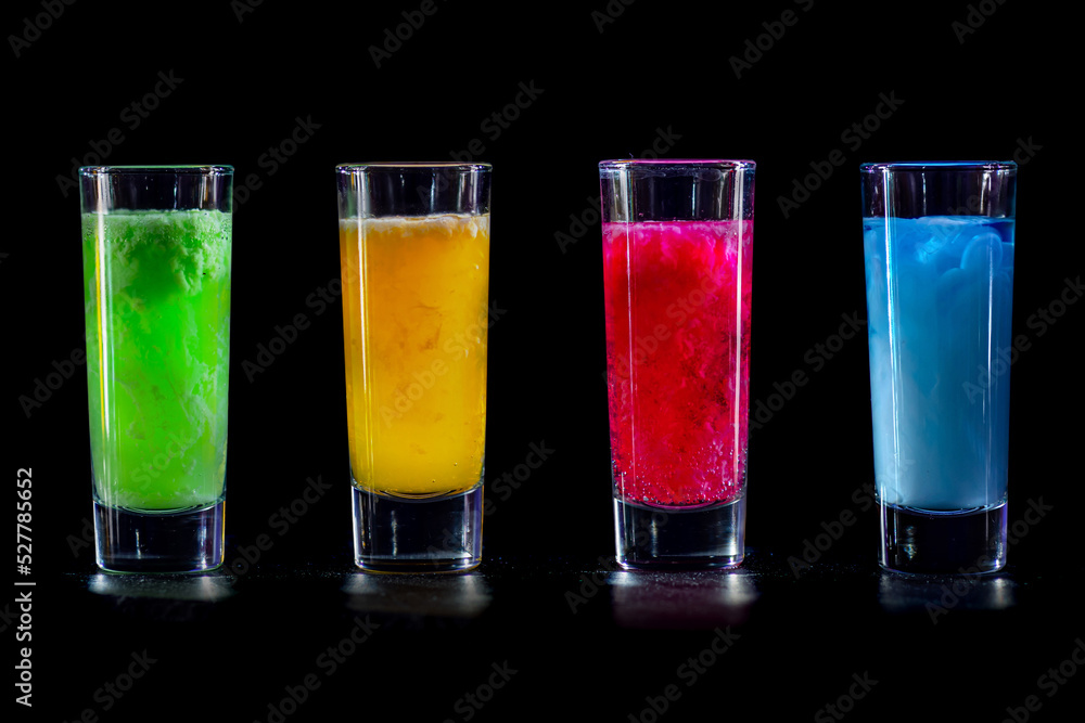 Cocktails Party Shots and Shooters on bar counter in a restaurant, pub. Miniature mixed drinks. Alcoholic cooler beverage at nightclub on dark background Cocktails Party Shots and Shooters on bar counter in a restaurant, pub. Miniature mixed drinks. Alcoholic cooler beverage at nightclub on dark background