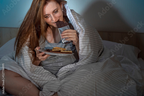 Φωτογραφία Woman late-night snacking in bed at home waking up hungry at night