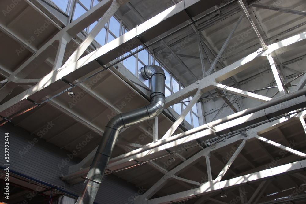 Curved ventilation pipe passing under the roof of the workshop