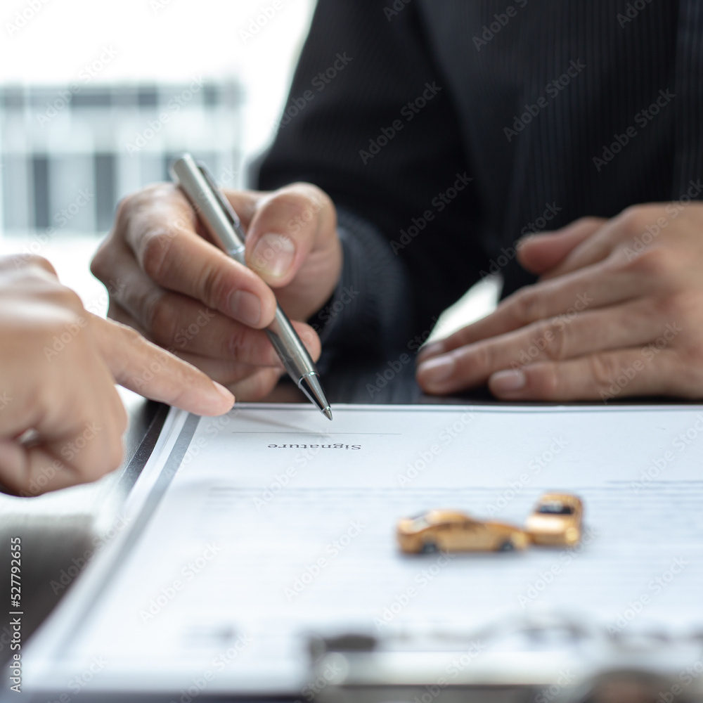 Car dealers or managers allow customers to sign documents and car sales agreements with insurance. Document signing and credit approval Concept.. Car dealers or managers allow customers to sign documents and car sales agreements with insurance. Document signing and credit approval Concept..