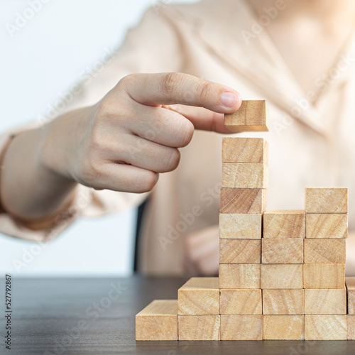 Arrange the wooden blocks into steps, higher the marketing strategy the more effort is required, Driving business at the peak concept.