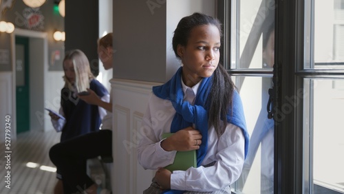 Konstfotografi Portrait of sad African-American teen student sitting on window sill in corridor