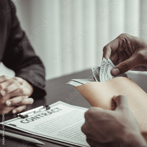 Businessmen give dollars to bribe employees in signing contracts to buy illegal land and real estate, Business fraud and social injustice, corruption and bribery concept.