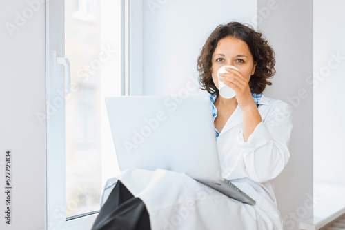 Doctor with laptop computer having a break drinking coffee