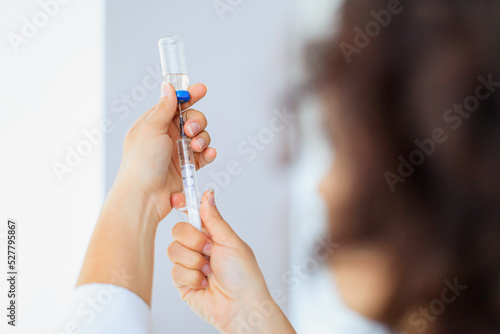 Female nurse holding vaccine syringe