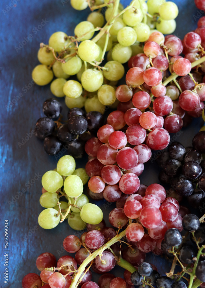 Black, green and red grapes on close up. Top view photo of seasonal fruits. Healthy eating concept. Black, green and red grapes on close up. Top view photo of seasonal fruits. Healthy eating concept.
