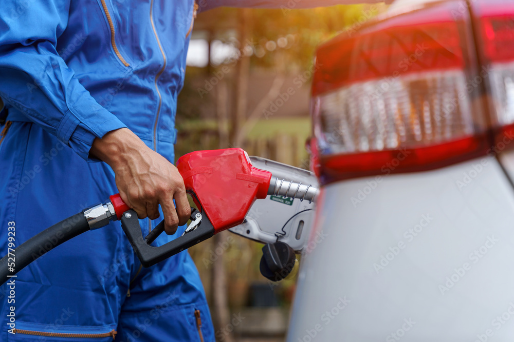 Close up man hands refueling a white car. higher oil prices. Close up man hands refueling a white car. higher oil prices.