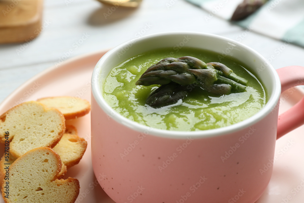 Delicious asparagus soup served on table, closeup Delicious asparagus soup served on table, closeup