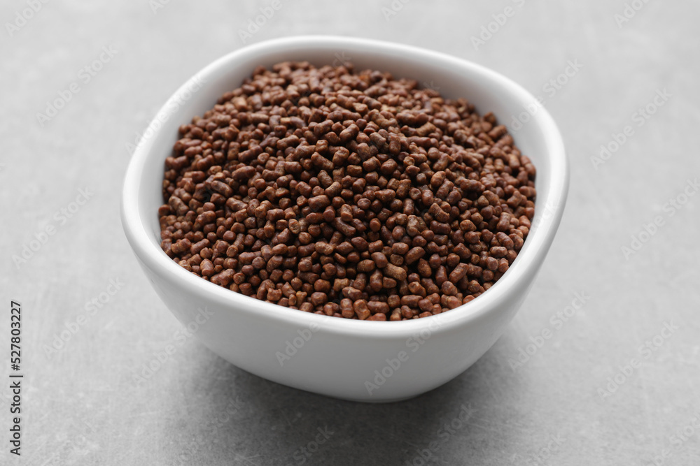 Buckwheat tea granules in bowl on light grey table, closeup Buckwheat tea granules in bowl on light grey table, closeup