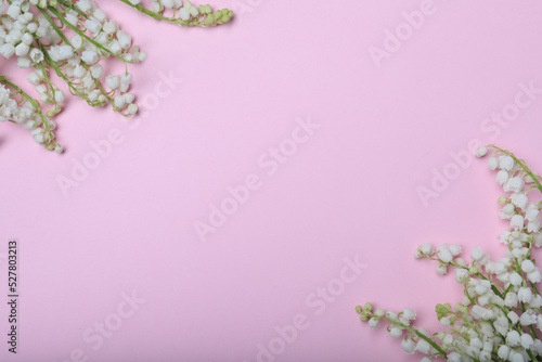 Beautiful lily of the valley flowers on pink background, flat lay. Space for text