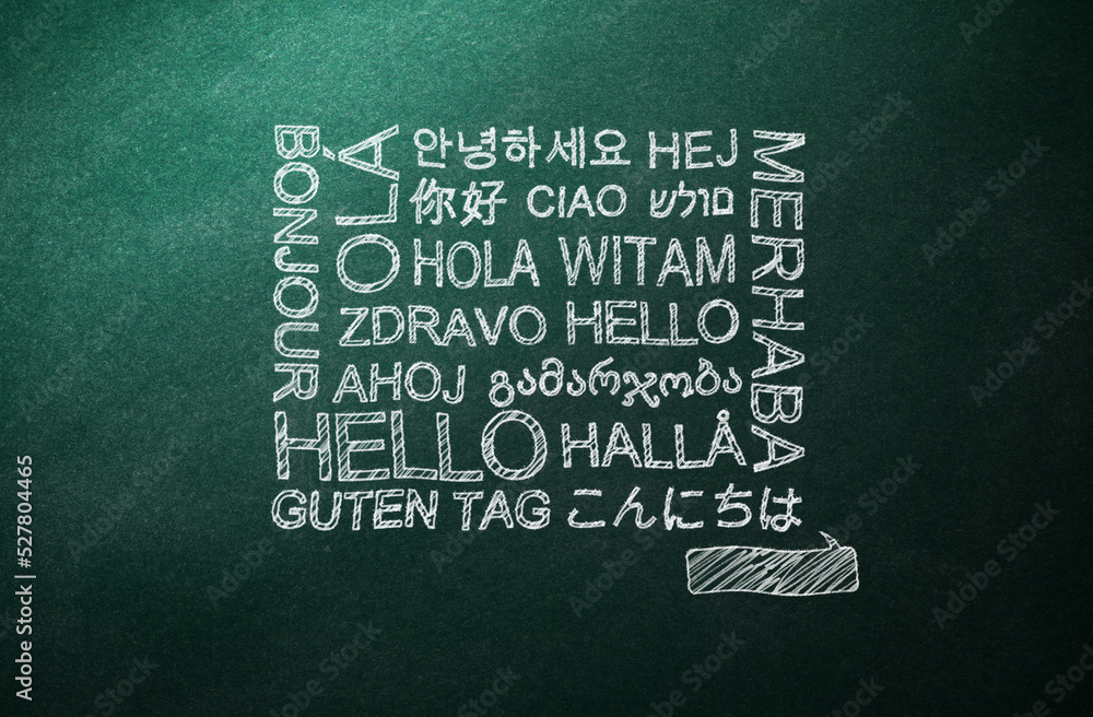 Greeting words in different foreign languages written on green chalkboard - obrazy, fototapety, plakaty 