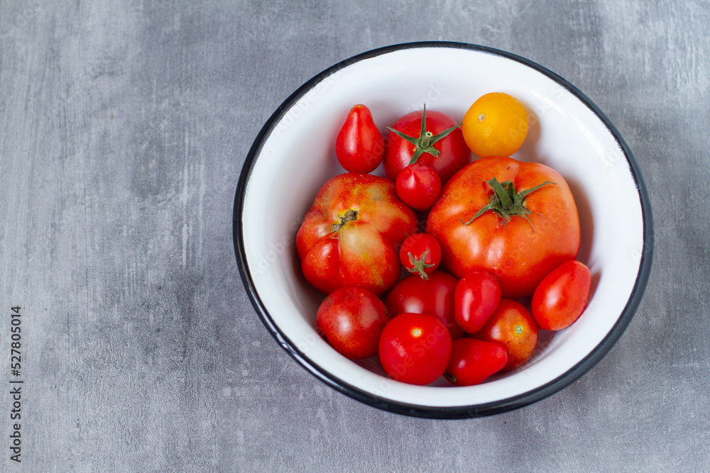 Different varieties of garden tomatoes in rustic metal bowl Different varieties of garden tomatoes in rustic metal bowl