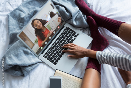 Biracial businesswoman showing report to young female freelancer working from home through laptop © vectorfusionart