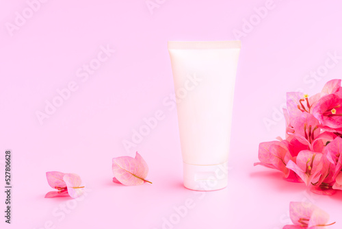 Cosmetic bottle tube with pink bougainvillea flowers on pink background