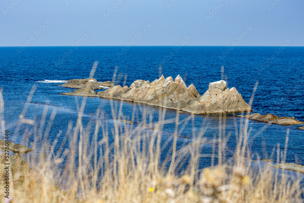 By the sea, Black Sea, Bulgaria. Rocks in the blue water By the sea, Black Sea, Bulgaria. Rocks in the blue water