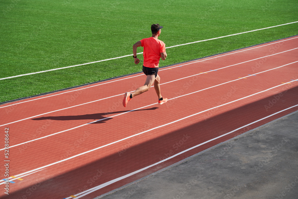 Sport man athlete is running on treadmillat the stadium