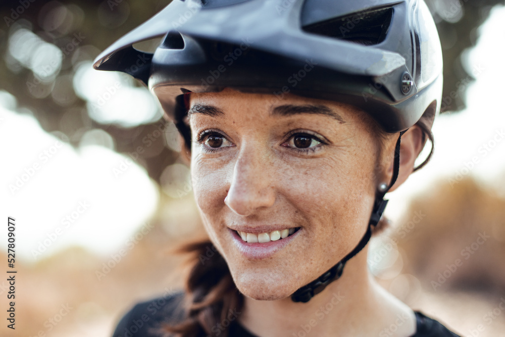 Woman buttoning helmet and bike near tree Woman buttoning helmet and bike near tree