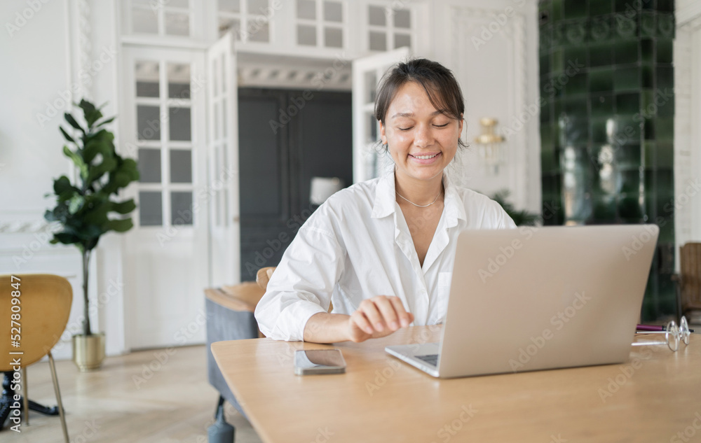 A female designer works in an office online doing a project on a website