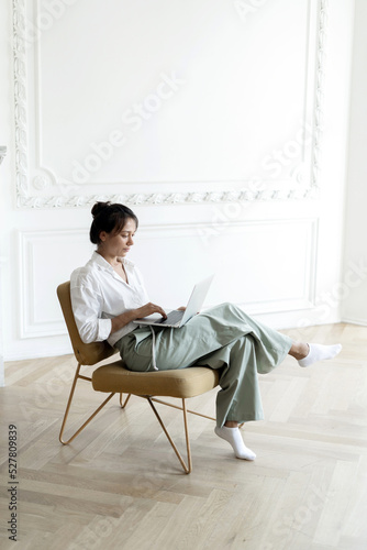 A female investor works in an office trades stocks online on the stock exchange uses a laptop © muse studio